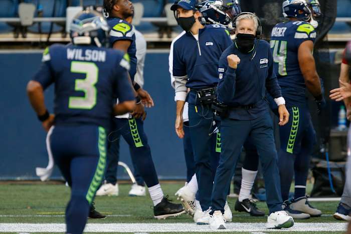 Seahawks head coach Pete Carroll wears his neck gaiter as he cheers on quarterback Russell Wilson. 